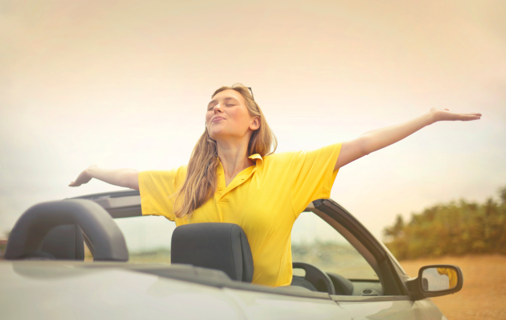 Vrouw met geel shirt in auto met open dak